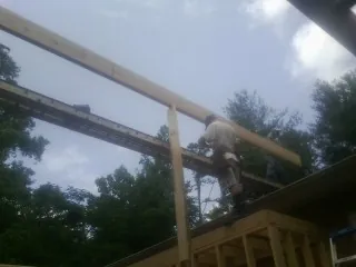 Carpenter setting a ridge beam over a new addition frame — Ice Dam Removal by Roofing Brothers in Hubertus