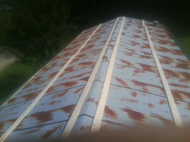 Rusted metal roof panels with new wood purlins before replacement — Storm Damage Roof Repair in Hubertus by Roofing Brothers