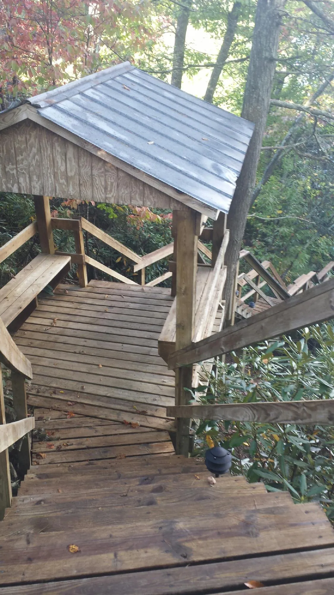 Metal roofed shelter over wooden steps on a wooded walkway — Skylight Repair & Installation work by our crew in Hubertus